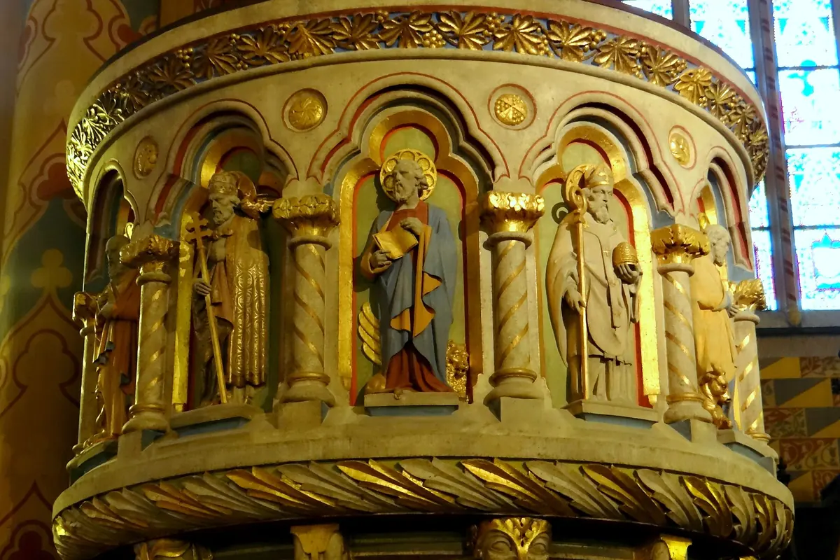 The round gilded pulpit of Matthias Church carved with figures of saints under small arches