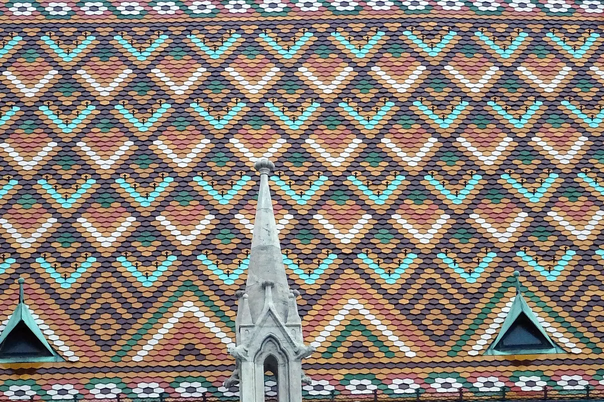 Close view of the church roof covered in glazed tiles in red, green, turquoise and cream, laid in a diamond pattern